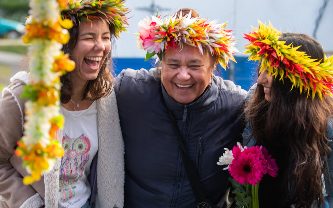 Three-women-wearing-leis-and-laughing-at-Otara-Markets-1@2x
